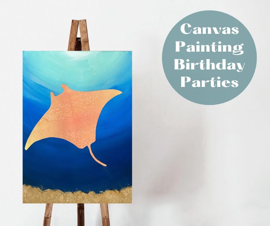 Canvas painting of an orange manta ray against a blue ocean background, on display at Bisque It Studio